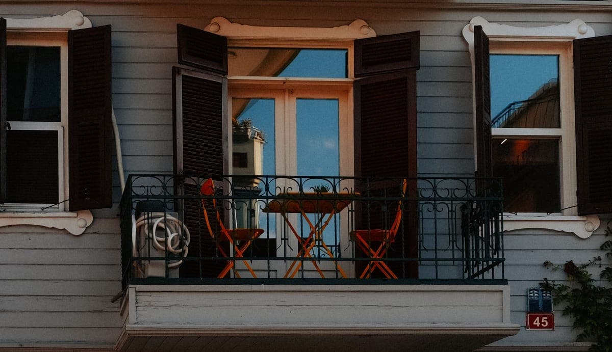 A small apartment balcony with a compact table and chairs